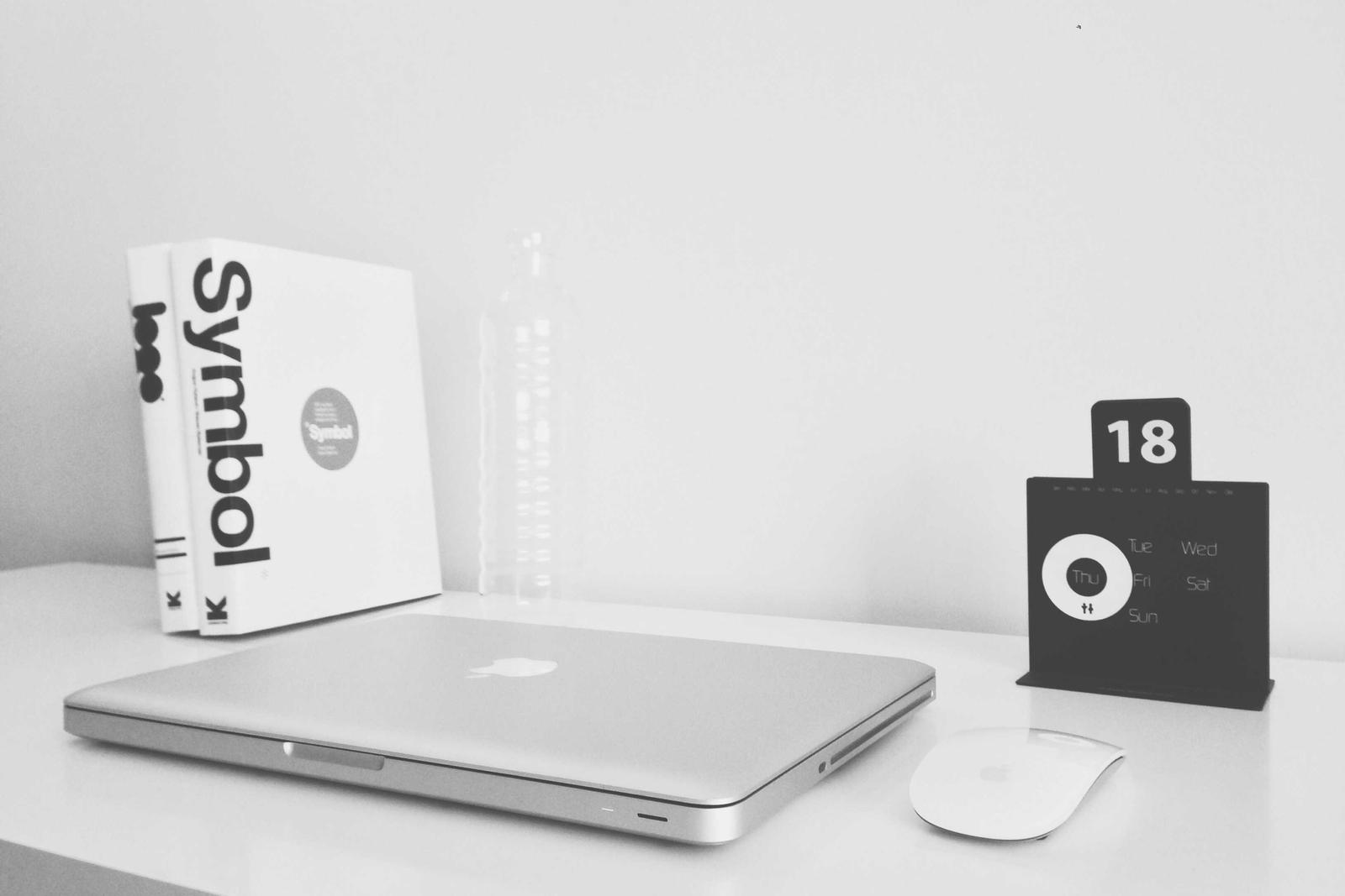 Aufgeräumter Schreibtisch mit Laptop, Büchern und Kalender — steht für redaktionelle Sorgfalt.